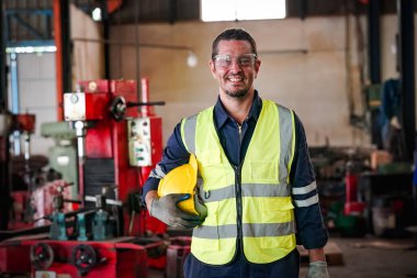 Erkek teknisyen bir robot kolu dijital tabletle programlar ve bir fabrikada robot montajı yapar. Fabrikada çıraklık mühendisliği programlayan robotlar..