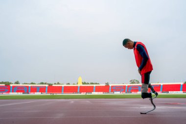 Sporcu fiziksel olarak engelli, stadyum yolunda koşuyor.