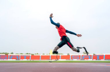 Sporcu fiziksel olarak engelli, stadyum yolunda koşuyor.