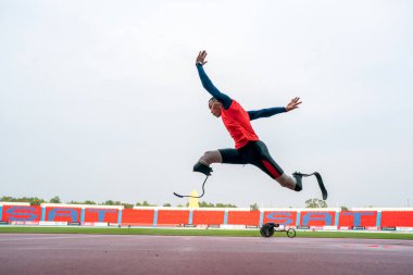 Sporcu fiziksel olarak engelli, stadyum yolunda koşuyor.