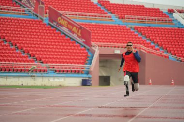 Sporcu fiziksel olarak engelli, stadyum yolunda koşuyor.