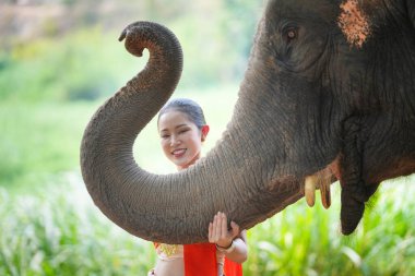 Ormanda fil başında duran genç bir kadının portresi.