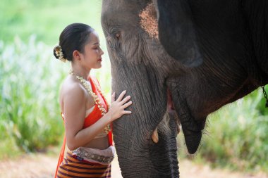 Ormanda fil başında duran genç bir kadının portresi.