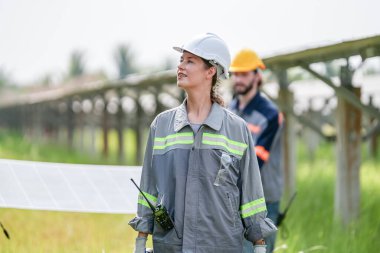 Solor voltaik paneller, güneş çiftliği inşaatında çalışan indusrty mühendisi.