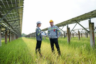 Solor voltaik paneller, güneş çiftliği inşaatında çalışan indusrty mühendisi.