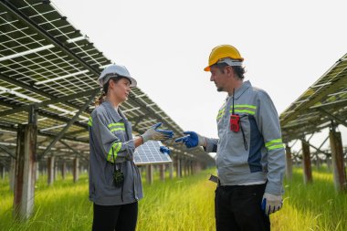 Solor voltaik paneller, güneş çiftliği inşaatında çalışan indusrty mühendisi.