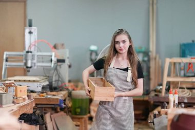 Genç bir kadının küçük işleri. Mobilya atölyesinde ahşabı ölçen genç ve güzel bir kadın işçi..