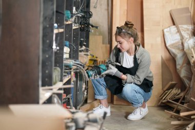 Genç bir kadının küçük işleri. Mobilya atölyesinde ahşabı ölçen genç ve güzel bir kadın işçi..