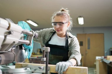 Genç bir kadının küçük işleri. Mobilya atölyesinde çalışan güzel genç bayan.