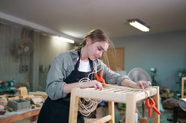 Marangoz DIY atölyesinde çalışan genç ve güzel bir kadın. Küçük işletme sahibi, mobilya fabrikasında çalışan genç bir kadın..