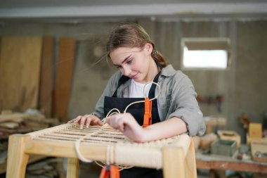 Marangoz DIY atölyesinde çalışan genç ve güzel bir kadın. Küçük işletme sahibi, mobilya fabrikasında çalışan genç bir kadın..