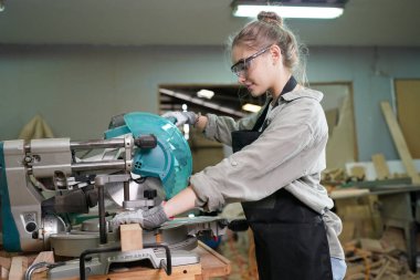 Marangoz DIY atölyesinde çalışan genç ve güzel bir kadın. Küçük işletme sahibi, mobilya fabrikasında çalışan genç bir kadın..