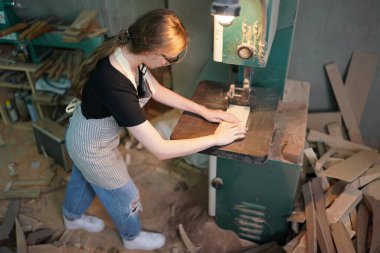 Marangoz DIY atölyesinde çalışan genç ve güzel bir kadın. Küçük işletme sahibi, mobilya fabrikasında çalışan genç bir kadın..