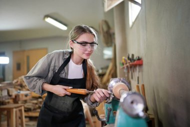 Marangoz DIY atölyesinde çalışan genç ve güzel bir kadın. Küçük işletme sahibi, mobilya fabrikasında çalışan genç bir kadın..