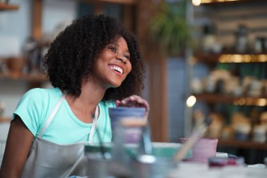 Genç Afro kız çömlekçi çömlekçi çömlek atölyesinde vazo yapıyor, işyeri sahibi.. 