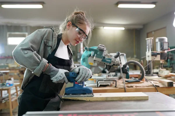 Marangoz DIY atölyesinde çalışan genç ve güzel bir kadın. Küçük işletme sahibi, mobilya fabrikasında çalışan genç bir kadın..