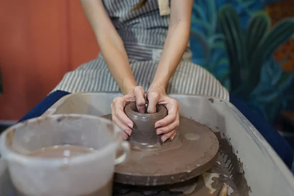 土船を形成しながら 陶器の車輪に座って 工芸品を使用してエプロンに集中した美しい職人のクローズアップ — ストック写真