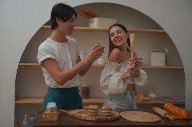 Gülümseyen çift mutfakta yemek pişiriyor. 