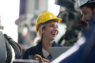 Robot mühendisleri fabrika deposunda robotik kolun bakımı üzerinde çalışıyorlar. İş teknolojisi.