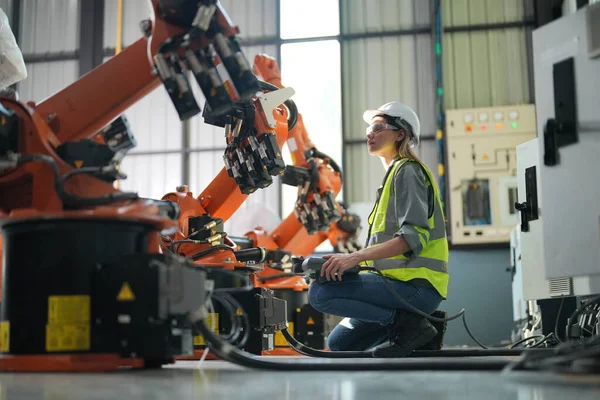 stock image Robotic Arm engineer checking  equipment in its with software of an Artificial Intelligence, Programming development technology work