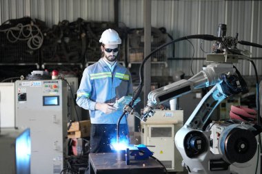 Robot mühendisi fabrika deposunda robotik kolun bakımı üzerinde çalışıyor. İş teknolojisi.