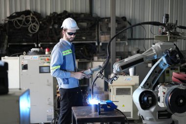 Robot mühendisi fabrika deposunda robotik kolun bakımı üzerinde çalışıyor. İş teknolojisi.