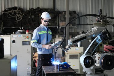 Robot mühendisi fabrika deposunda robotik kolun bakımı üzerinde çalışıyor. İş teknolojisi.