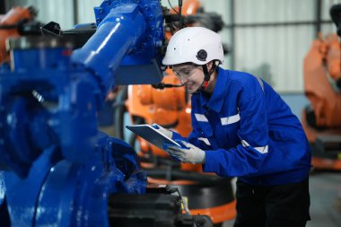 Robot mühendisi fabrika deposunda robotik kolun bakımı üzerinde çalışıyor. İş teknolojisi.