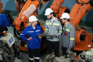 Robot mühendisleri fabrika deposunda robotik kolun bakımı üzerinde çalışıyorlar. İş teknolojisi.