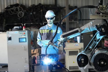 Robot mühendisi fabrika deposunda robotik kolun bakımı üzerinde çalışıyor. İş teknolojisi.