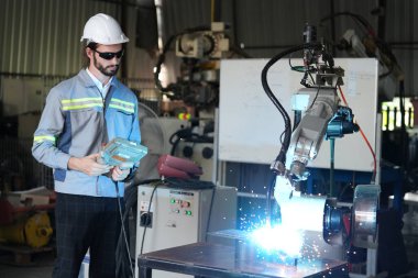 Robot mühendisi fabrika deposunda robotik kolun bakımı üzerinde çalışıyor. İş teknolojisi.