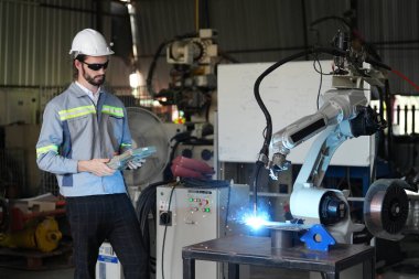 Robot mühendisi fabrika deposunda robotik kolun bakımı üzerinde çalışıyor. İş teknolojisi.