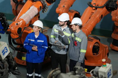Robot mühendisleri fabrika deposunda robotik kolun bakımı üzerinde çalışıyorlar. İş teknolojisi.