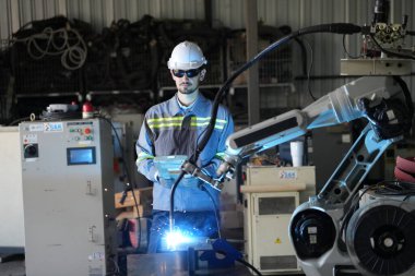Robot mühendisi fabrika deposunda robotik kolun bakımı üzerinde çalışıyor. İş teknolojisi.