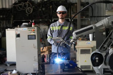 Robot mühendisi fabrika deposunda robotik kolun bakımı üzerinde çalışıyor. İş teknolojisi.