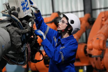 Robot mühendisi fabrika deposunda robotik kolun bakımı üzerinde çalışıyor. İş teknolojisi.