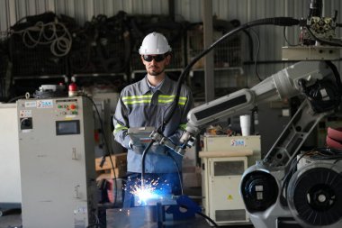 Robot mühendisi fabrika deposunda robotik kolun bakımı üzerinde çalışıyor. İş teknolojisi.