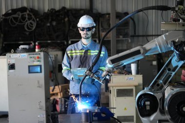 Robot mühendisi fabrika deposunda robotik kolun bakımı üzerinde çalışıyor. İş teknolojisi.