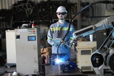 Robot mühendisi fabrika deposunda robotik kolun bakımı üzerinde çalışıyor. İş teknolojisi.