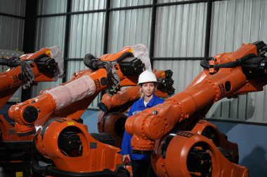 Robot mühendisi fabrika deposunda robotik kolun bakımı üzerinde çalışıyor. İş teknolojisi.