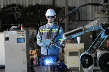 Robot mühendisi fabrika deposunda robotik kolun bakımı üzerinde çalışıyor. İş teknolojisi.