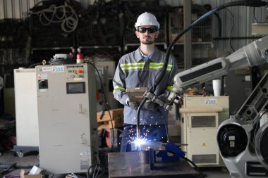 Robot mühendisi fabrika deposunda robotik kolun bakımı üzerinde çalışıyor. İş teknolojisi.