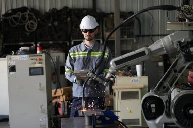 Robot mühendisi fabrika deposunda robotik kolun bakımı üzerinde çalışıyor. İş teknolojisi.