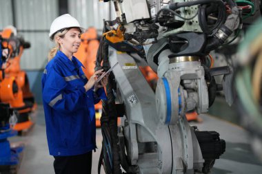 Robot mühendisi fabrika deposunda robotik kolun bakımı üzerinde çalışıyor. İş teknolojisi.