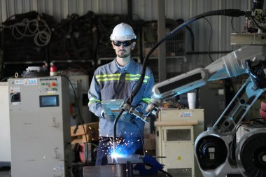 Robot mühendisi fabrika deposunda robotik kolun bakımı üzerinde çalışıyor. İş teknolojisi.