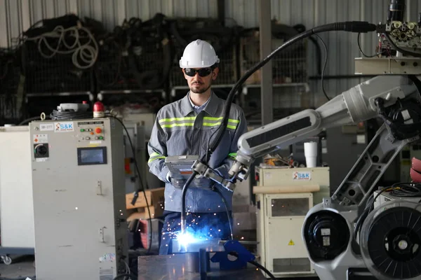 Robot mühendisi fabrika deposunda robotik kolun bakımı üzerinde çalışıyor. İş teknolojisi.