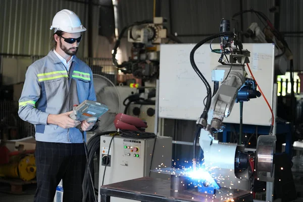 Robot mühendisi fabrika deposunda robotik kolun bakımı üzerinde çalışıyor. İş teknolojisi.