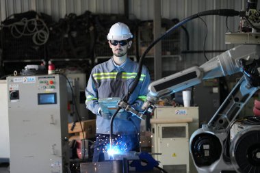 Robot mühendisi fabrika deposunda robotik kolun bakımı üzerinde çalışıyor. İş teknolojisi.
