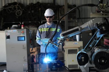 Robot mühendisi fabrika deposunda robotik kolun bakımı üzerinde çalışıyor. İş teknolojisi.