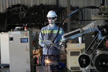 Robot mühendisi fabrika deposunda robotik kolun bakımı üzerinde çalışıyor. İş teknolojisi.